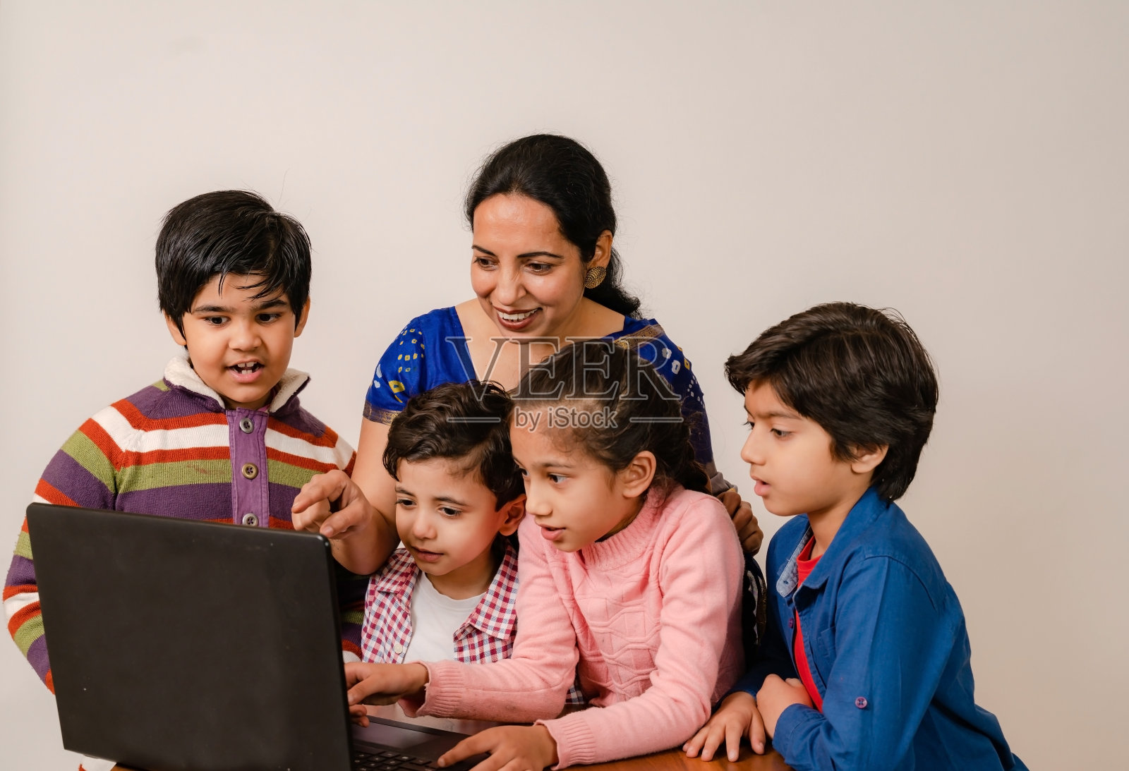 教师教学组的孩子们在笔记本电脑上在线上课照片摄影图片