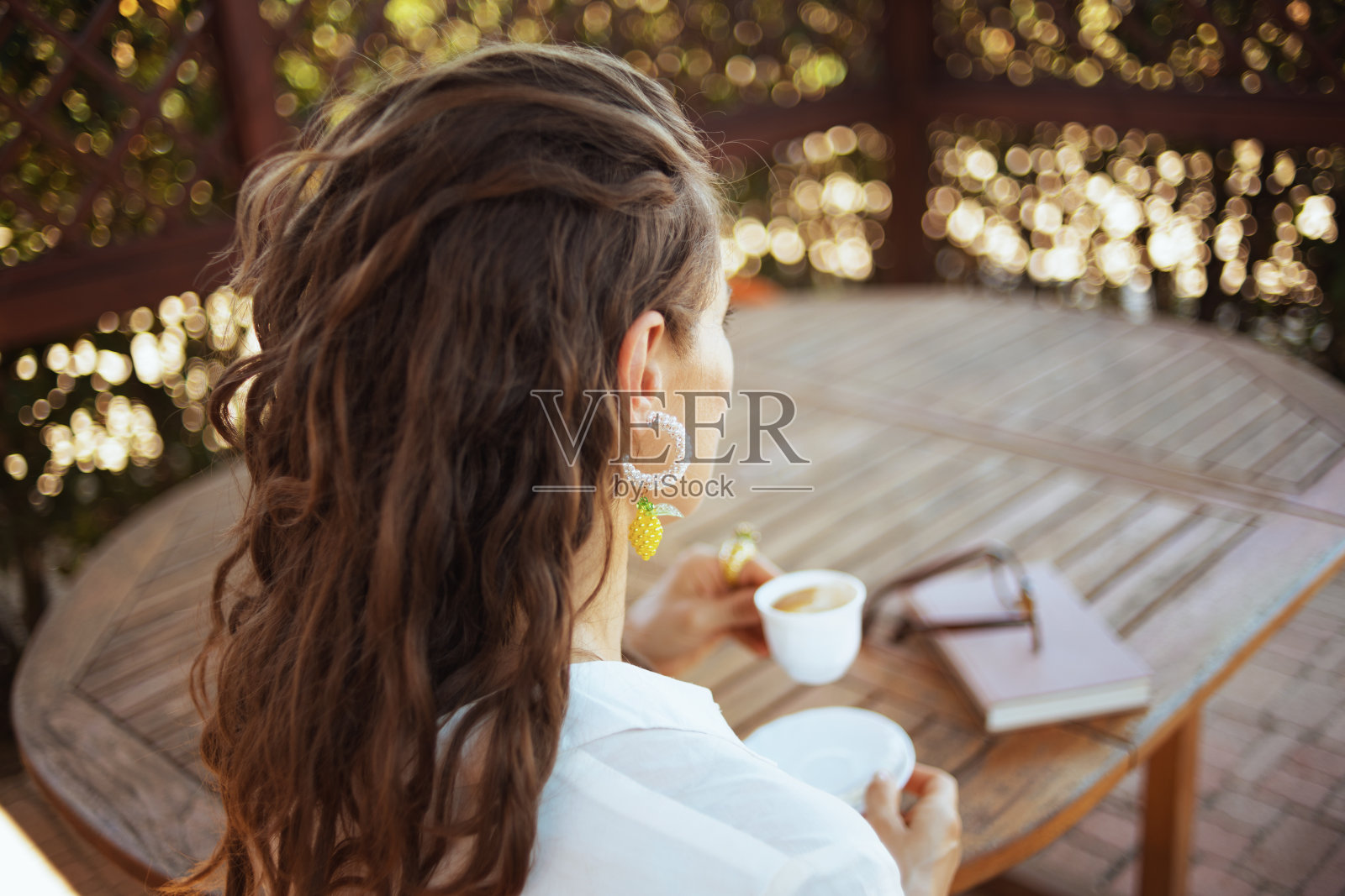 穿着白衬衫坐在桌旁沉思时尚的女人照片摄影图片