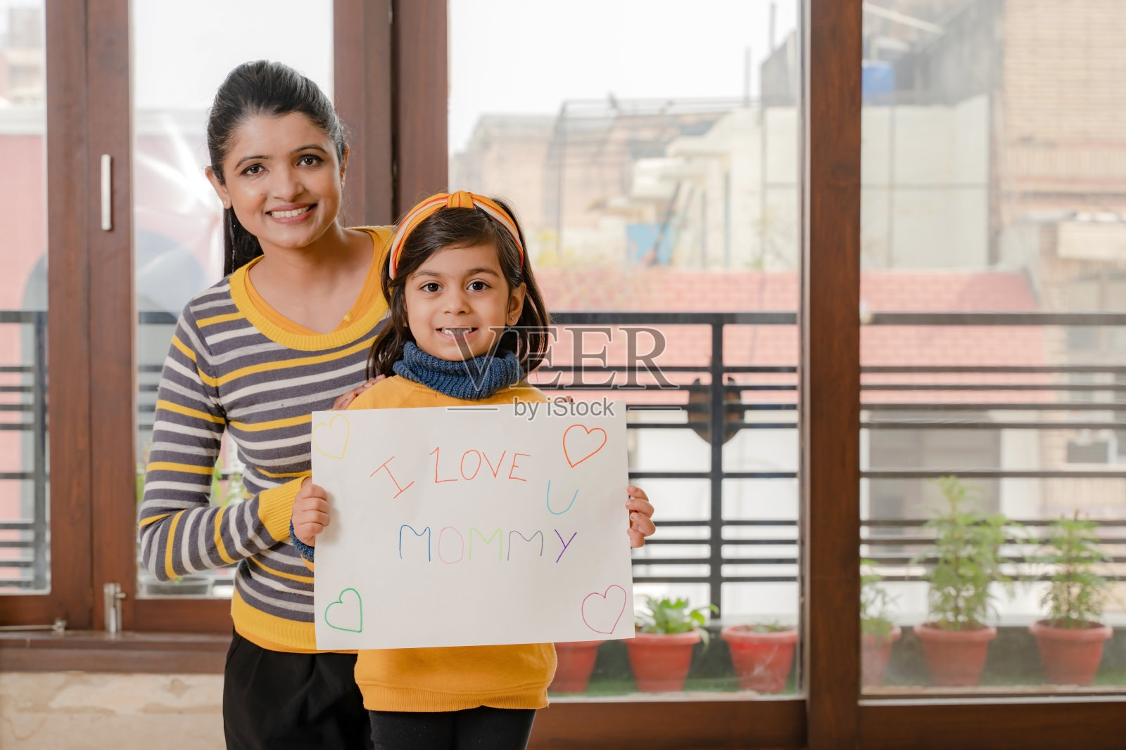 和看着镜头的女儿在一起的母亲照片摄影图片