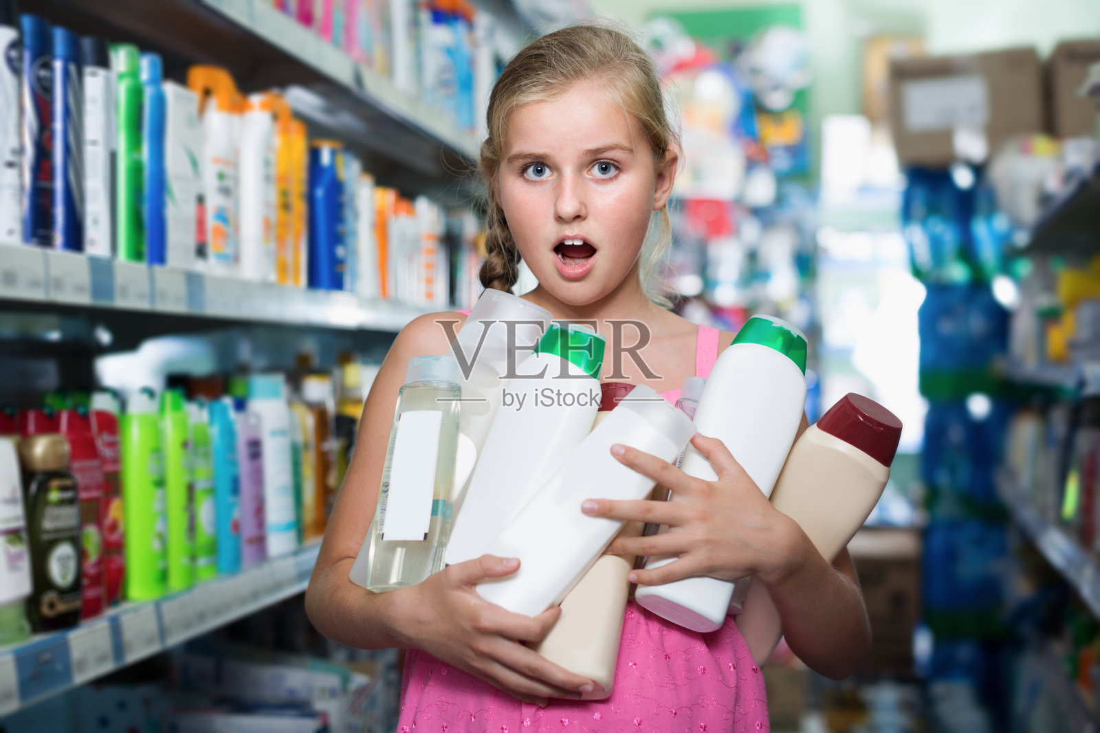 可爱的女孩拿着很多发膜和沐浴露照片摄影图片