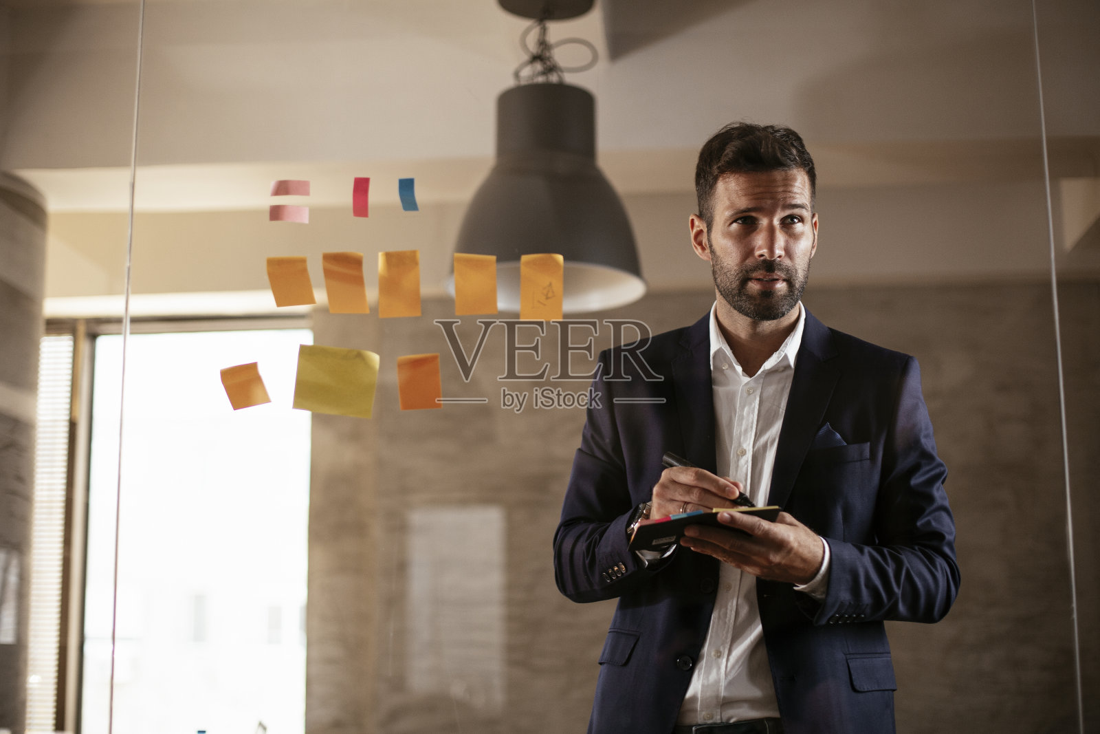 会议室的商人在玻璃墙上使用便利贴。照片摄影图片