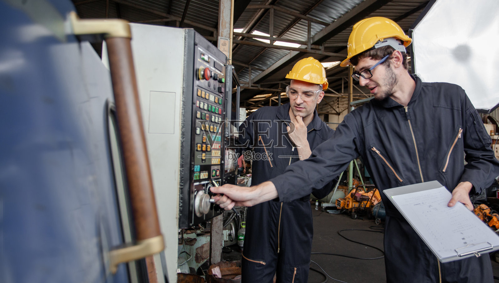 两个工人在一个工业工厂。协同生产活动…工人和工程师在工厂检查和检查生产过程照片摄影图片