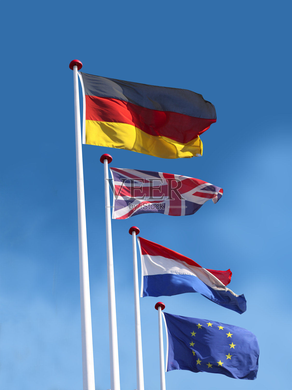 旗杆上有德国、英国、法国和欧盟的国旗。上面是德国国旗。照片摄影图片
