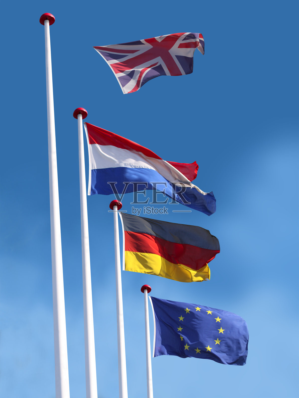 旗杆上悬挂着法国、德国和欧盟的国旗。英国国旗正离开旗杆飞走。照片摄影图片