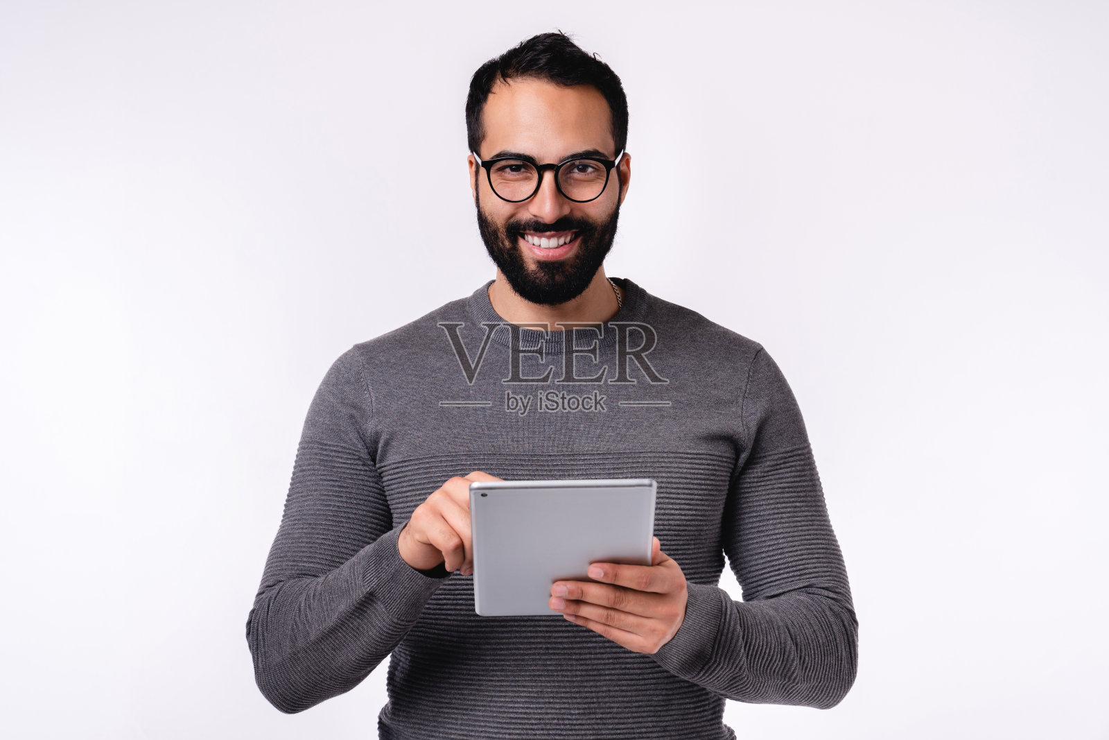 在白色背景上使用平板电脑的休闲装中东男子照片摄影图片