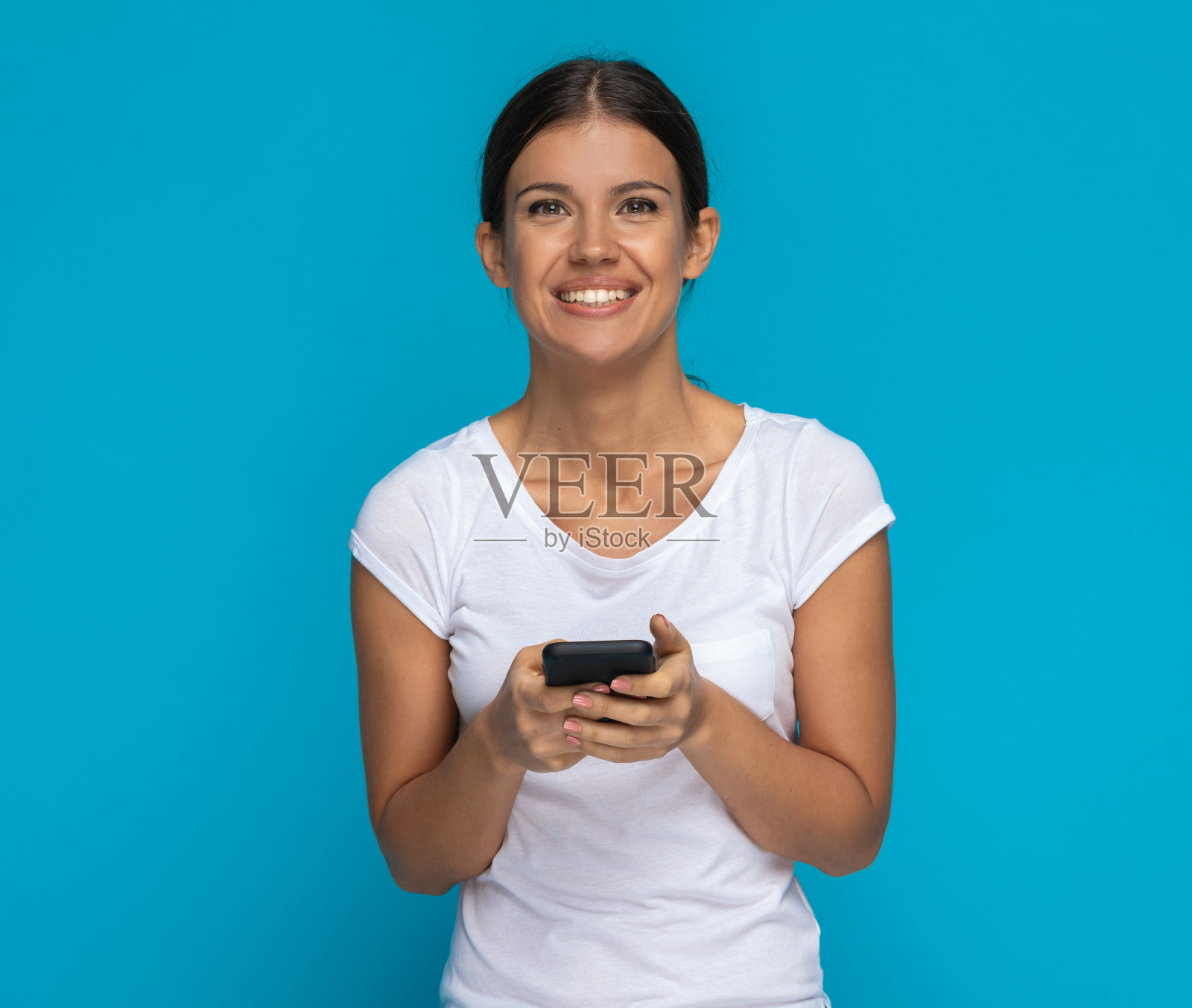 年轻快乐随意的女人在她的手机短信照片摄影图片