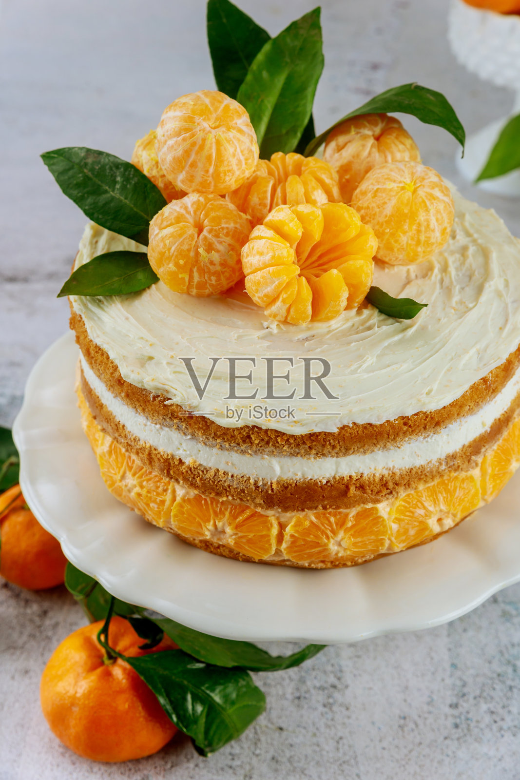 蛋糕上面是带叶子的橘子。照片摄影图片