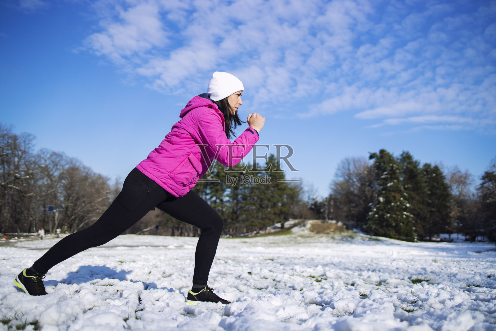 冬天在公园里跑步的女人。照片摄影图片