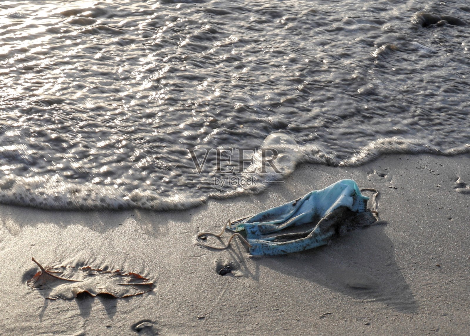 海滩上散落着防护口罩的风景照片摄影图片