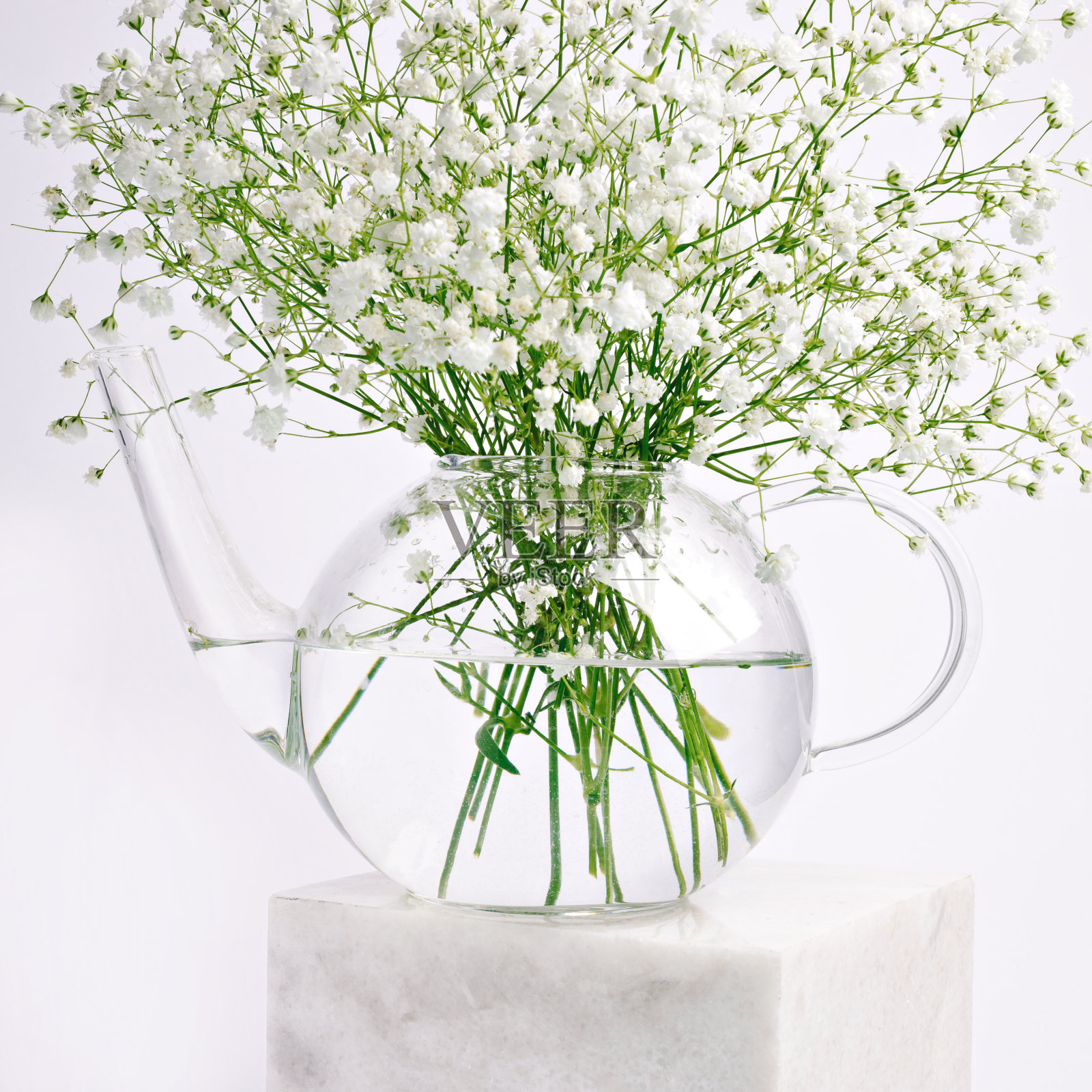 明亮的大理石立方体上放着一束鲜花的玻璃花瓶照片摄影图片