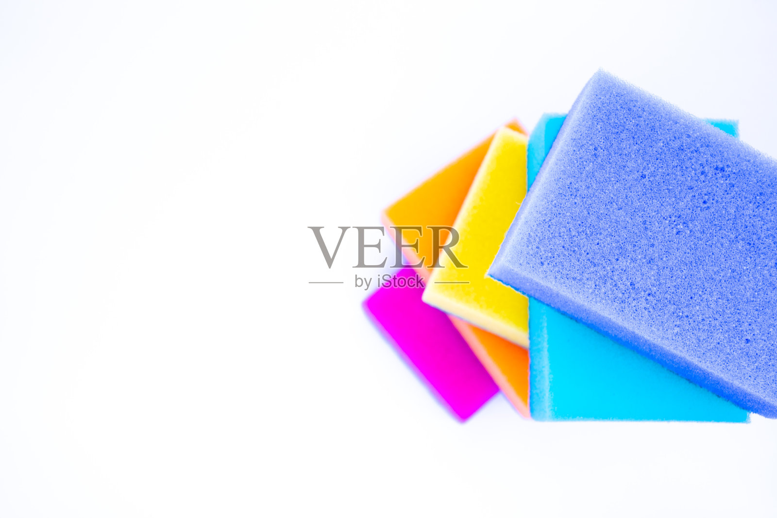 俯视图海绵洗涤盘子，在一个白色的背景，孤立。五彩缤纷的海绵像彩虹一样相互依偎。本空间照片摄影图片