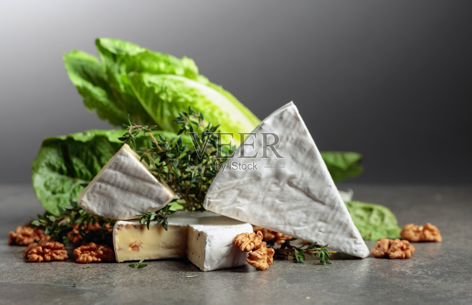 新鲜的布里干酪配生菜，百里香和核桃。照片摄影图片