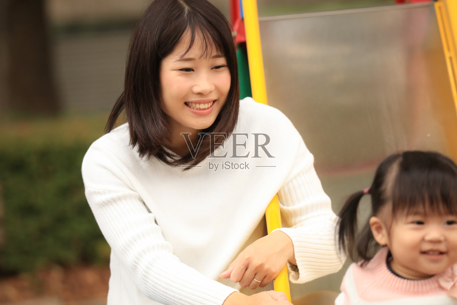 父母和孩子在滑梯上玩照片摄影图片