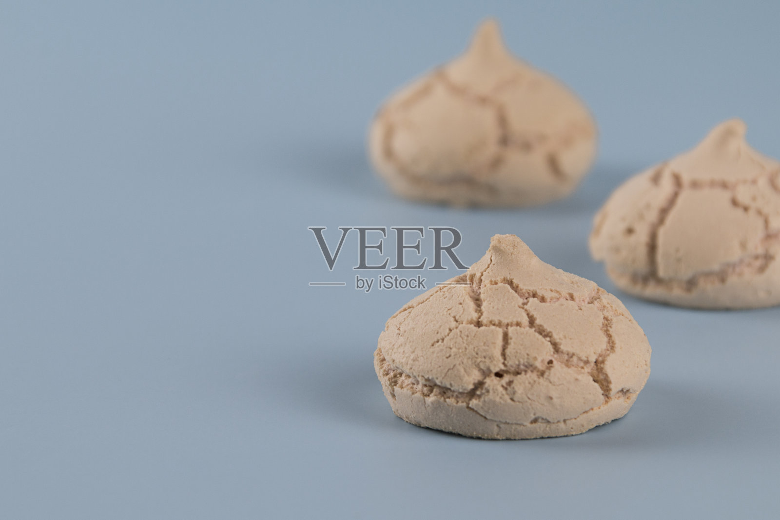 蓝色背景上的蛋白糖霜。近距离照片摄影图片