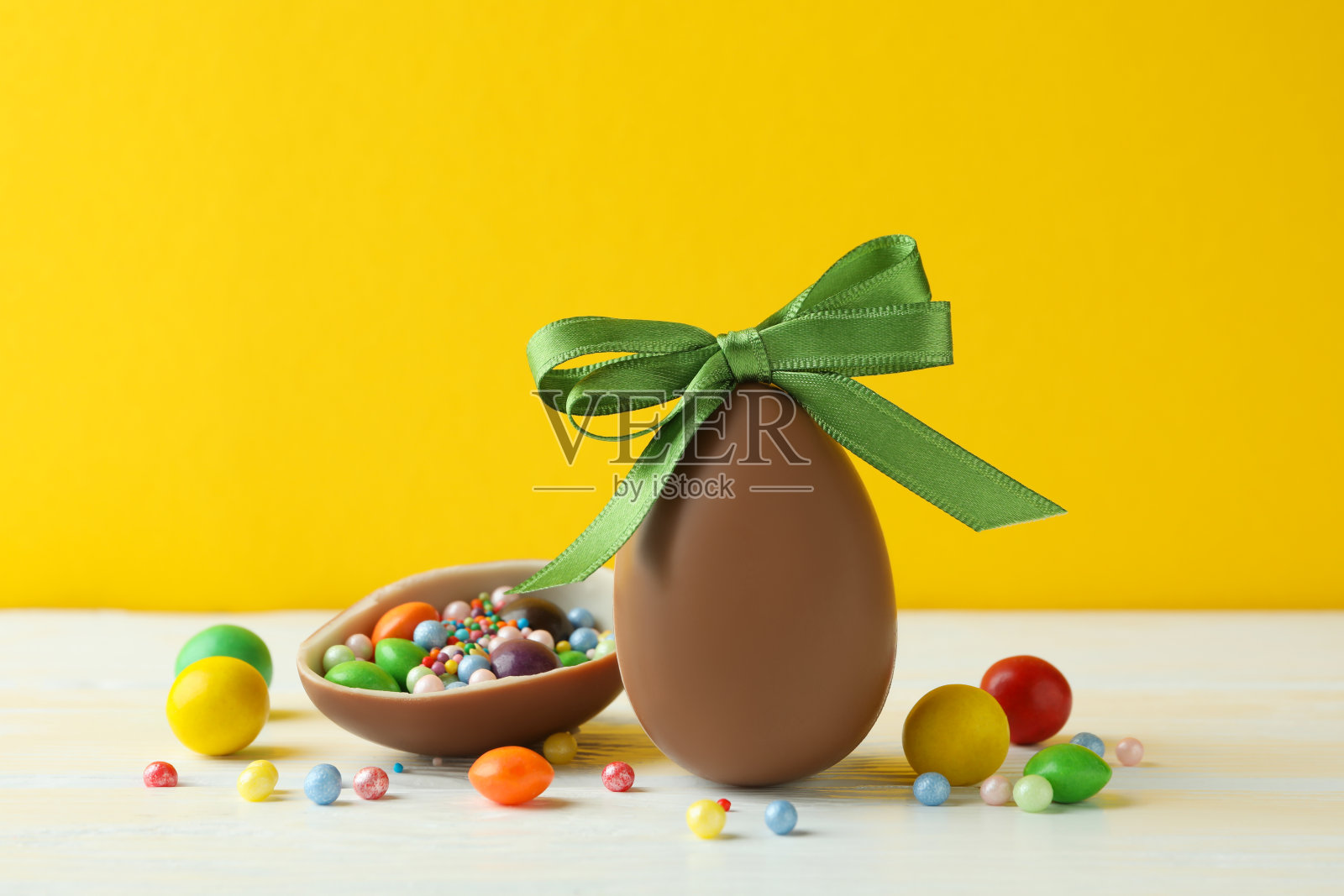 白色的木桌上放着复活节巧克力蛋和糖果照片摄影图片