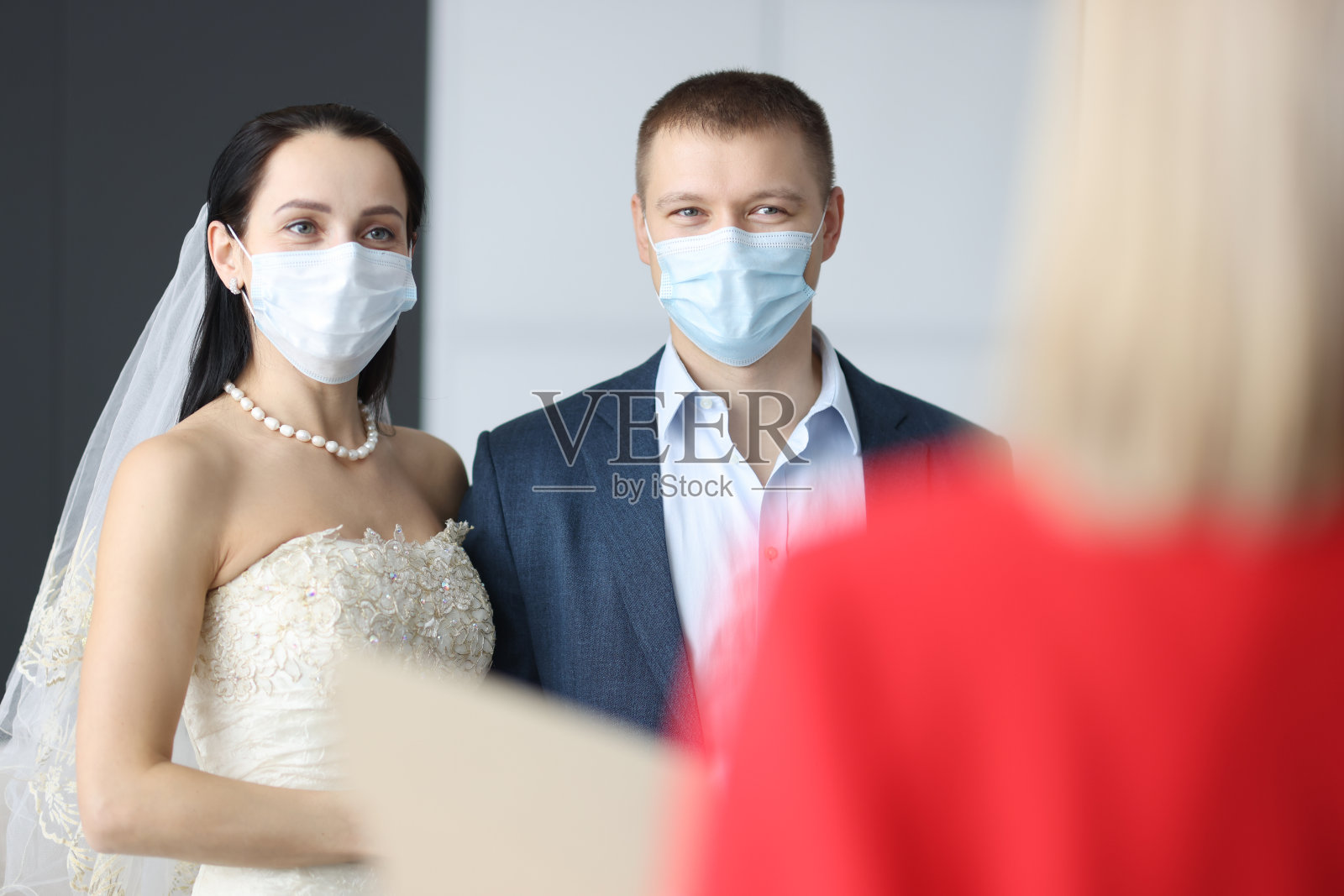 身着婚礼礼服和医用防护面具的男女出席仪式照片摄影图片