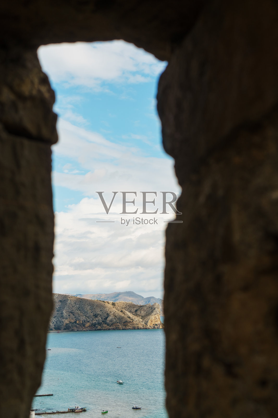 透过城堡的窗户可以看到海岸。照片摄影图片