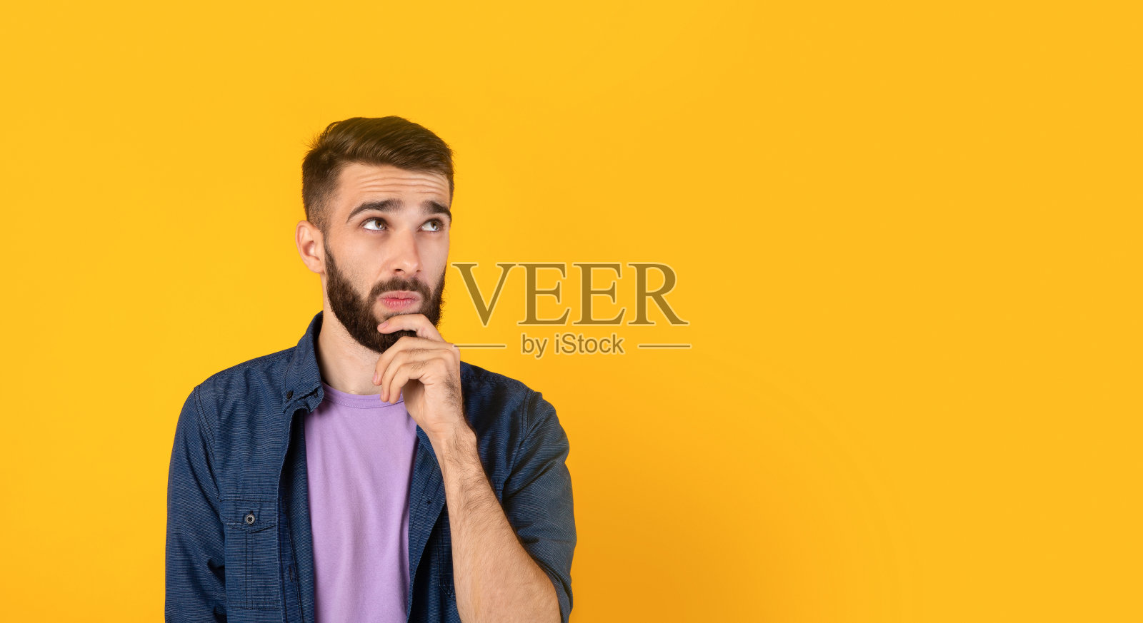 梦幻般的白人在思考着什么，在橙色的背景下触摸着下巴，带有复制空间的横幅设计照片摄影图片