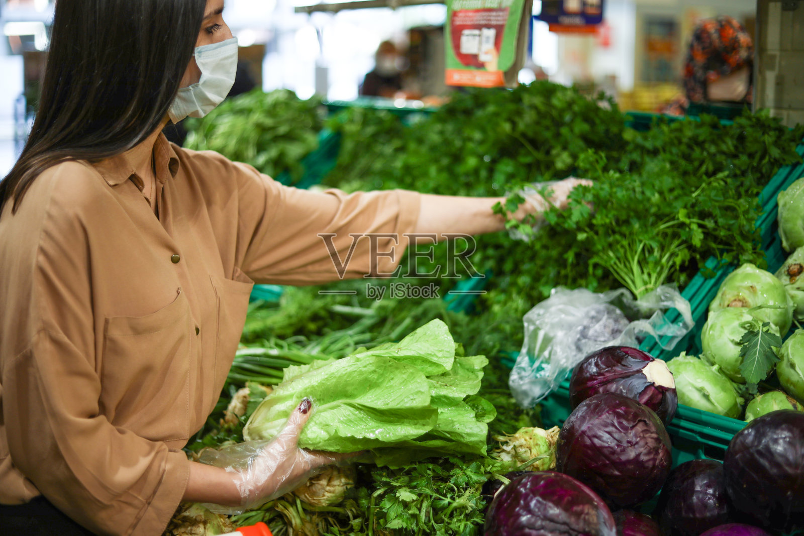 戴口罩的妇女在疫情中购买新鲜蔬菜照片摄影图片