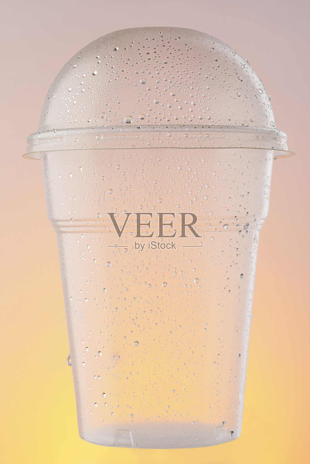 空塑料外卖杯，水杯。冰冷的一次性杯子，与水滴凝结在橙色的背景照片摄影图片