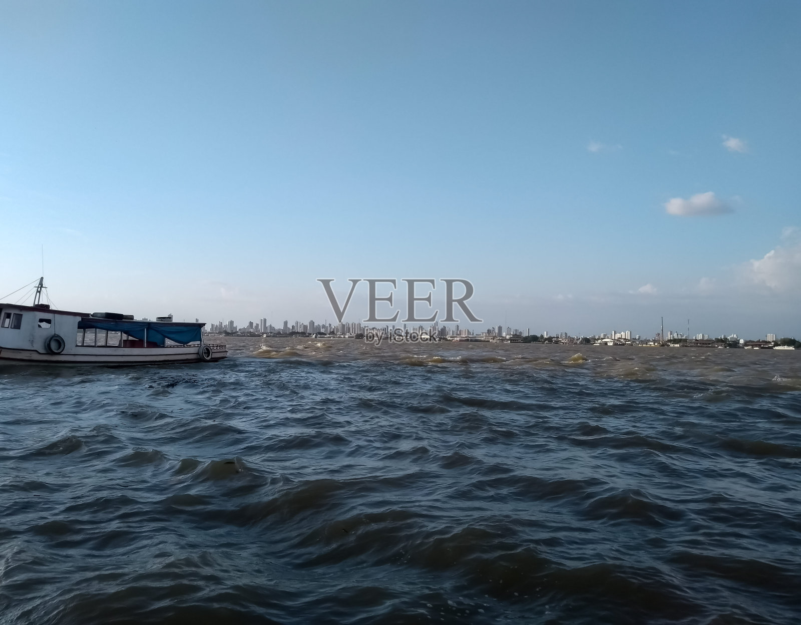 下午晚些时候，在瓜马河上的一艘小船上，在Ilha do Combu和Belém城市之间的渡口上。照片摄影图片