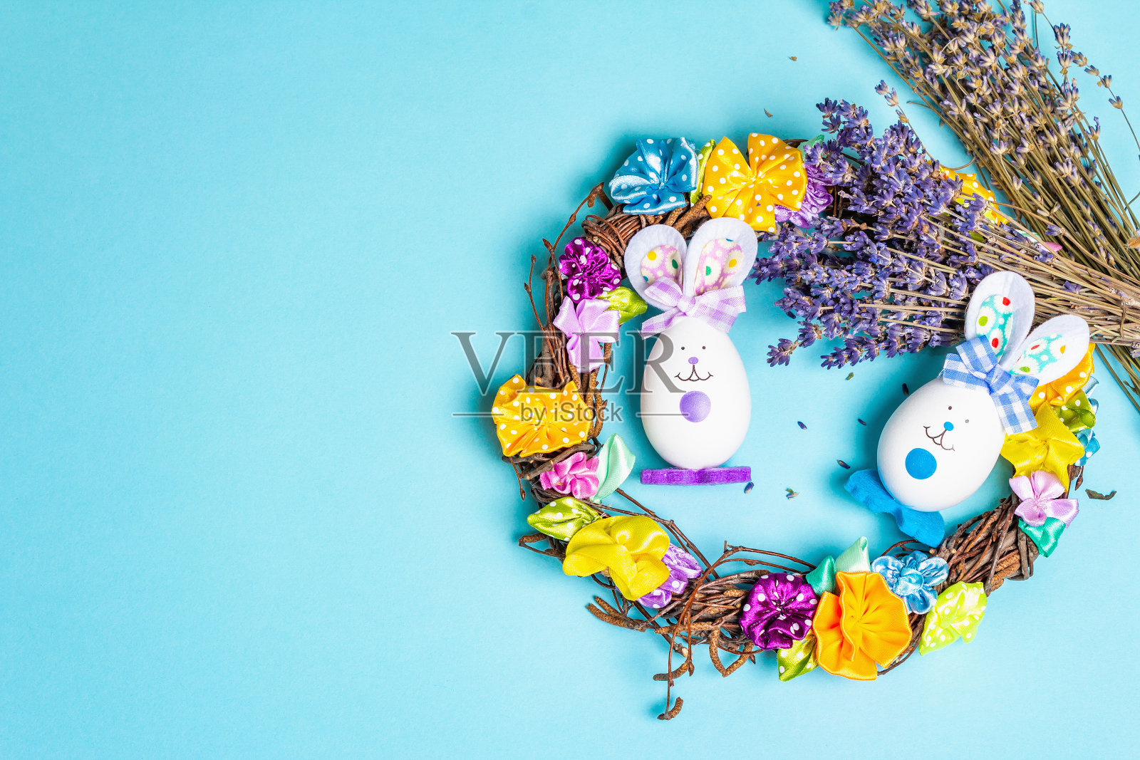 传统的复活节符号概念。用鸡蛋自制的可爱兔子，柳条花环，温和的郁金香照片摄影图片