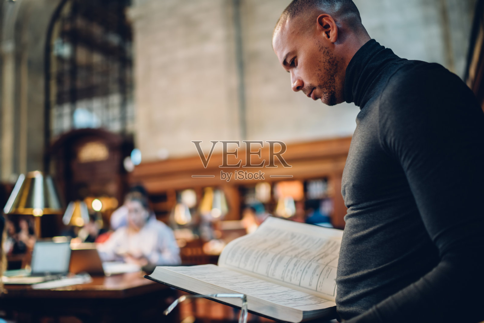 严肃的男科学家拿着百科全书为教育项目查找信息，聪明博学的本科生花时间在公共图书馆阅读文献学习照片摄影图片