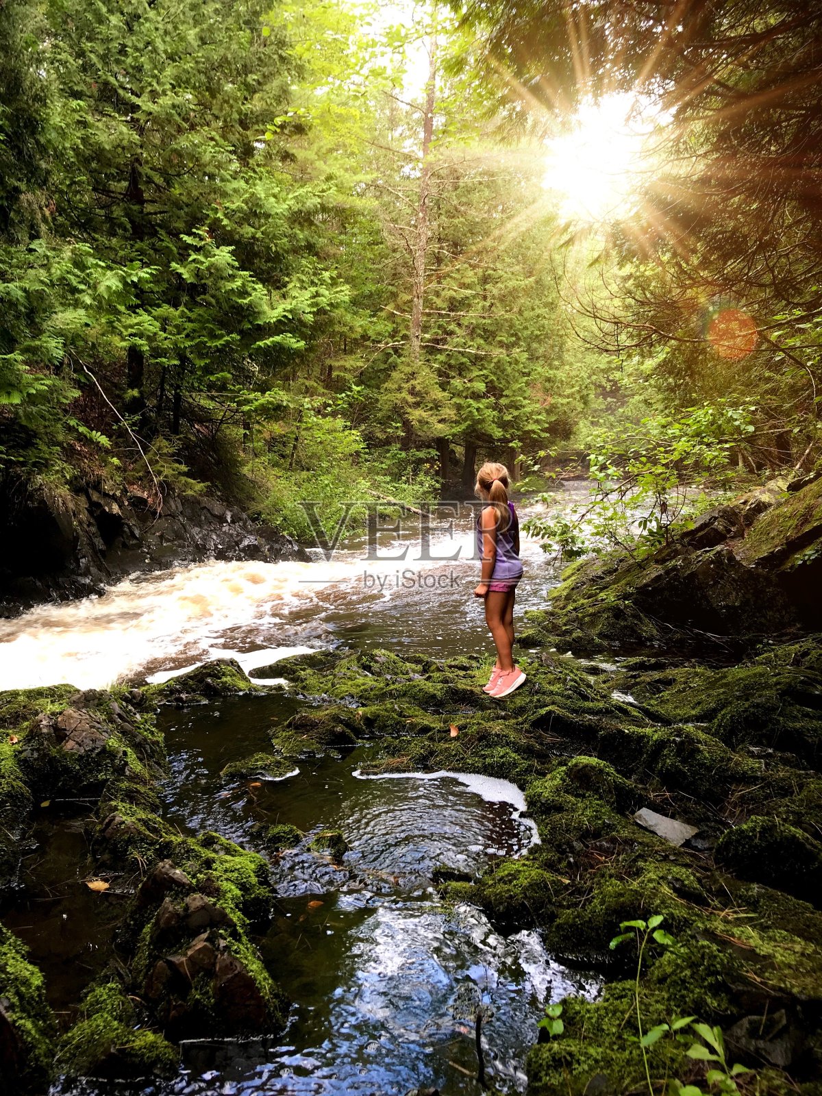 在阳光下冒险，孩子们在河上一个秘密的地方玩耍照片摄影图片