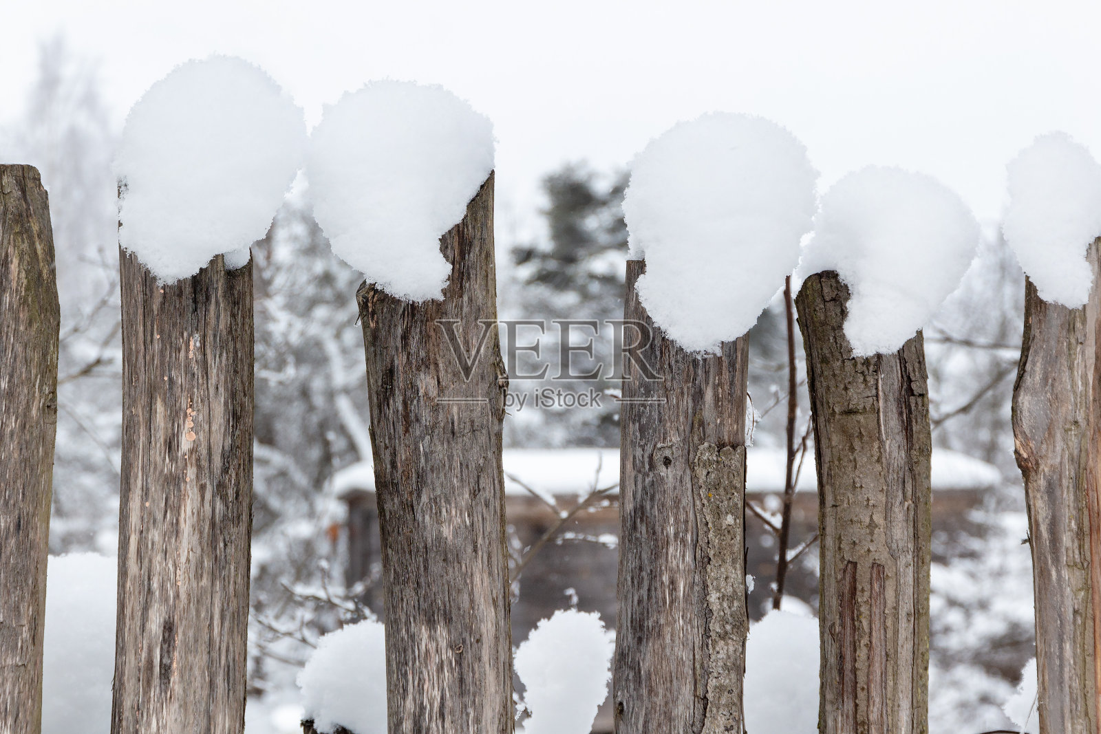用覆盖着雪的粗树枝做成的木栅栏照片摄影图片