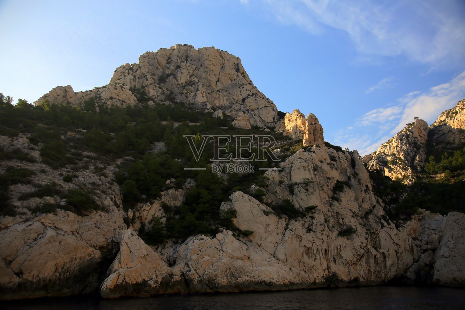 法国马赛，卡兰克斯国家公园，日落时海面上的岩石悬崖照片摄影图片