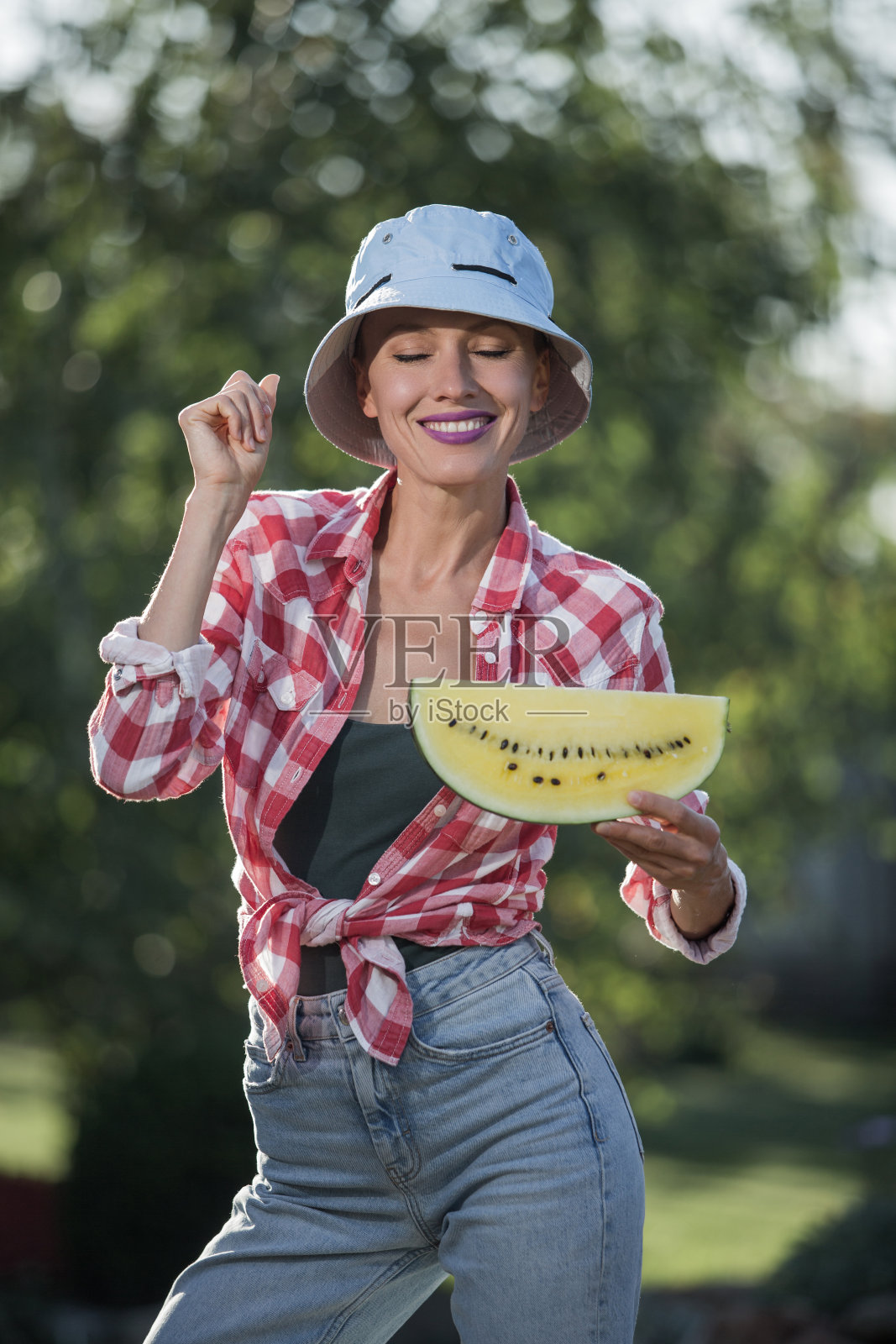 美丽的女人在吃黄色的西瓜照片摄影图片