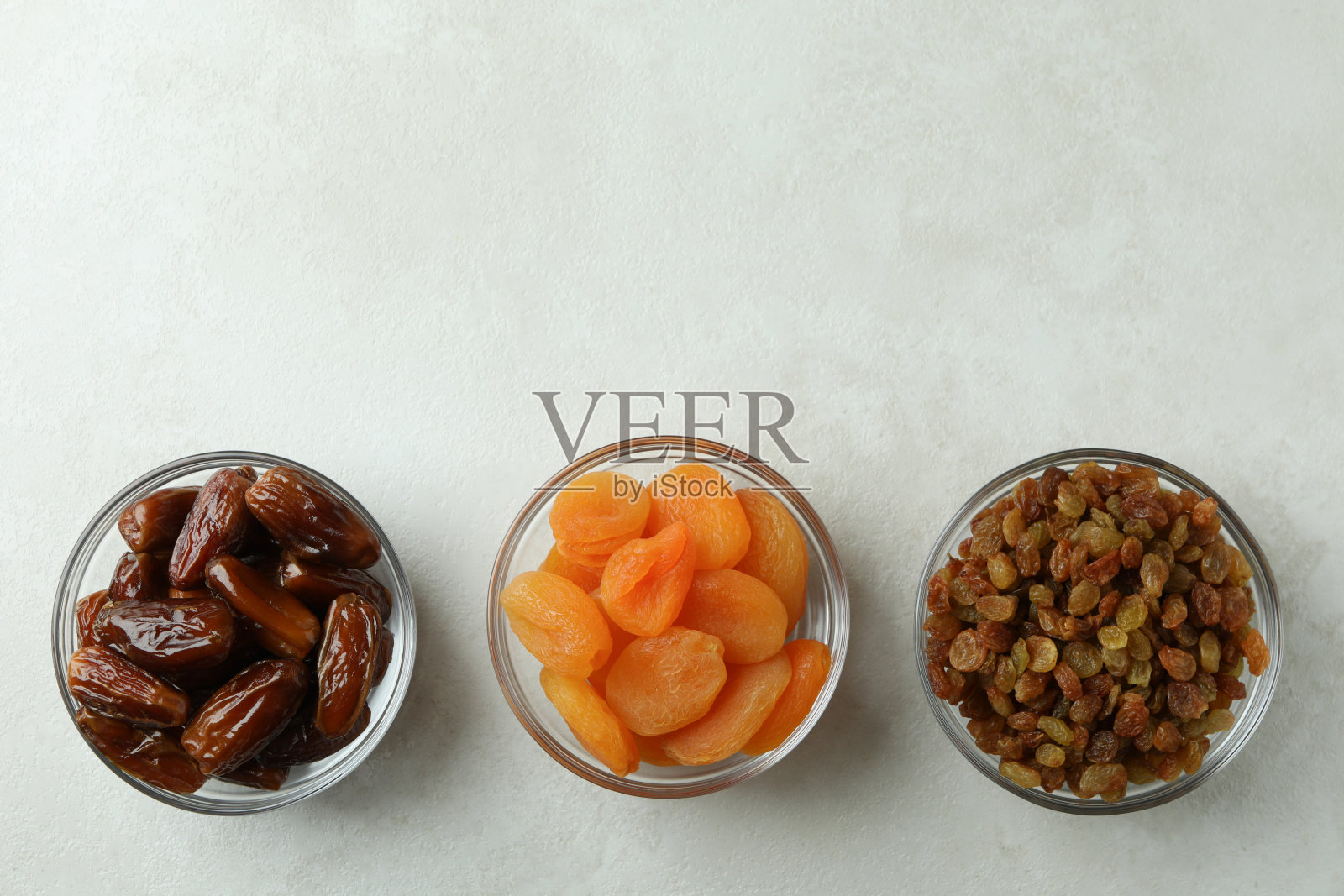 玻璃碗与干食物在白色纹理的背景照片摄影图片