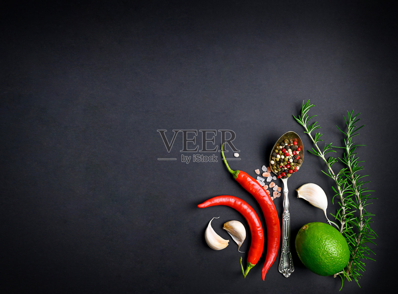 各种香料勺，辣椒，大蒜，拷贝空间，黑色背景。照片摄影图片