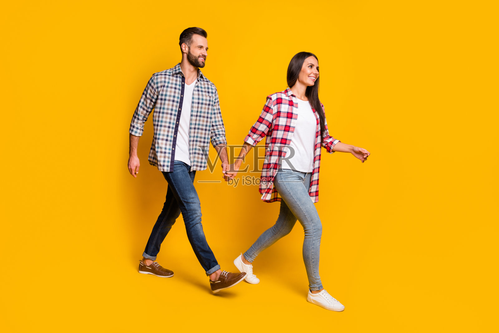 照片肖像丈夫和妻子的全身视图手拉手孤立行走在生动的黄色背景照片摄影图片