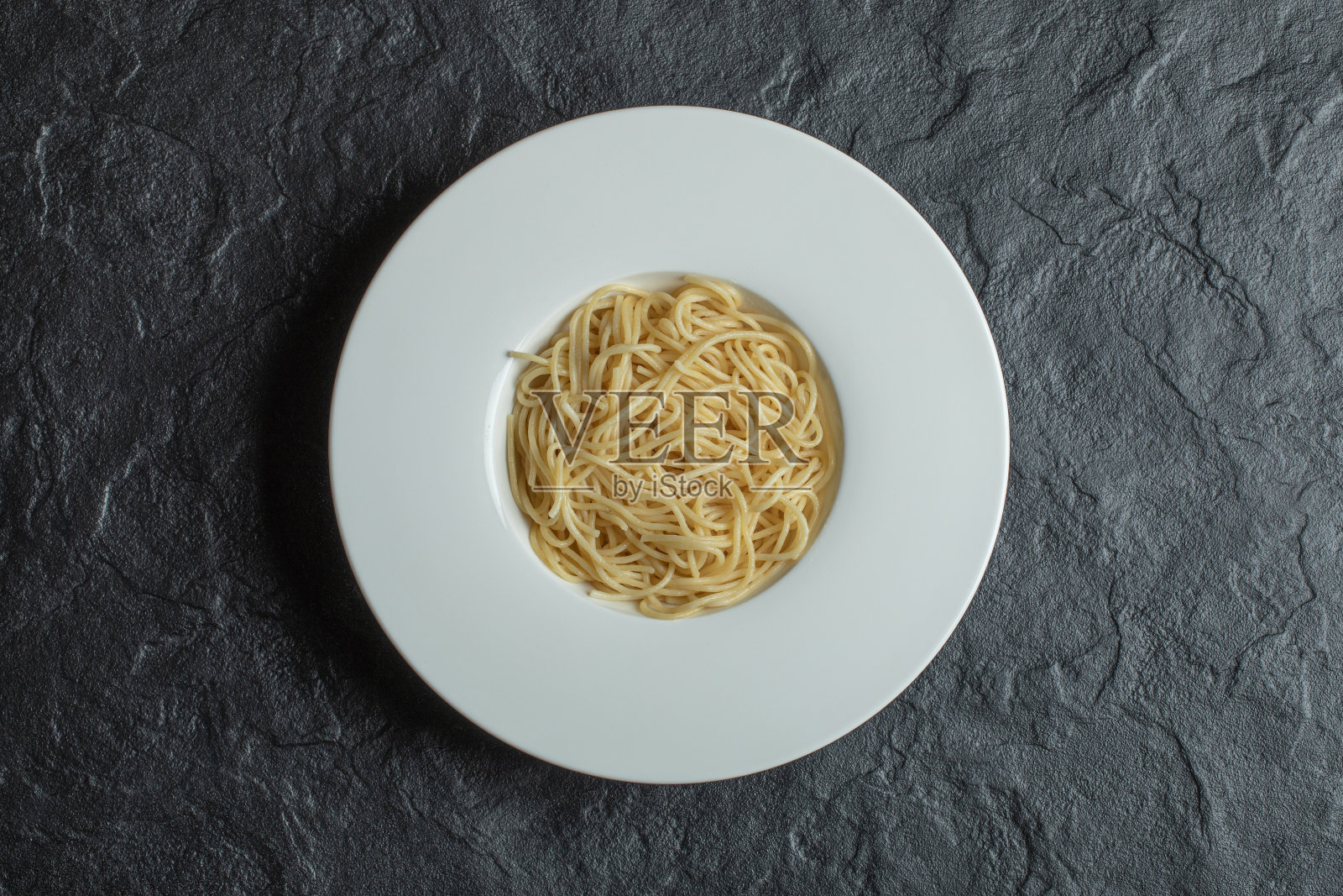 美味的面条在一个白色的盘子在一个黑暗的背景照片摄影图片