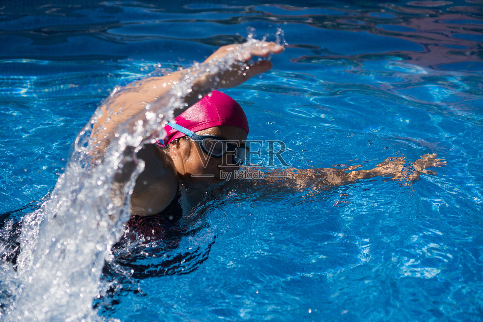 游泳池里的年轻女子照片摄影图片