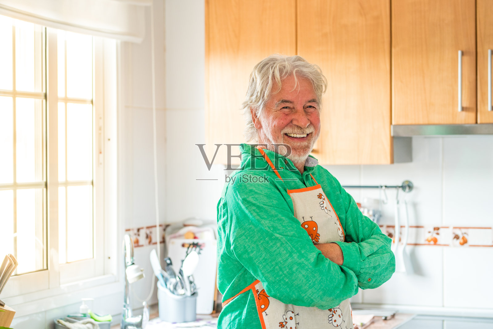 一个成熟的男人或年长的人微笑着看着相机在厨房做饭在家照片摄影图片