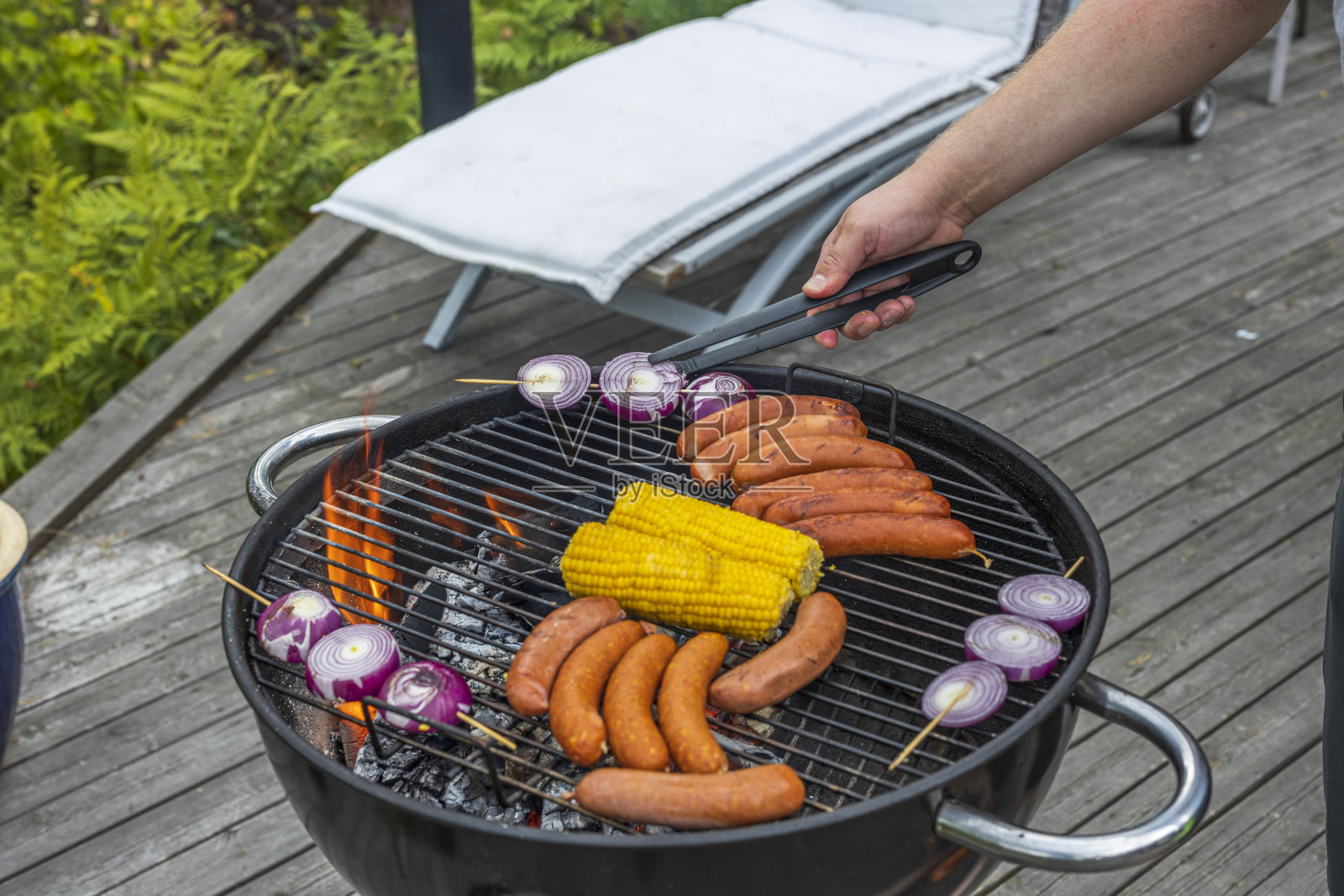 近距离观看烧烤香肠，玉米和洋葱在户外在夏天的一天。健康饮食的概念。照片摄影图片