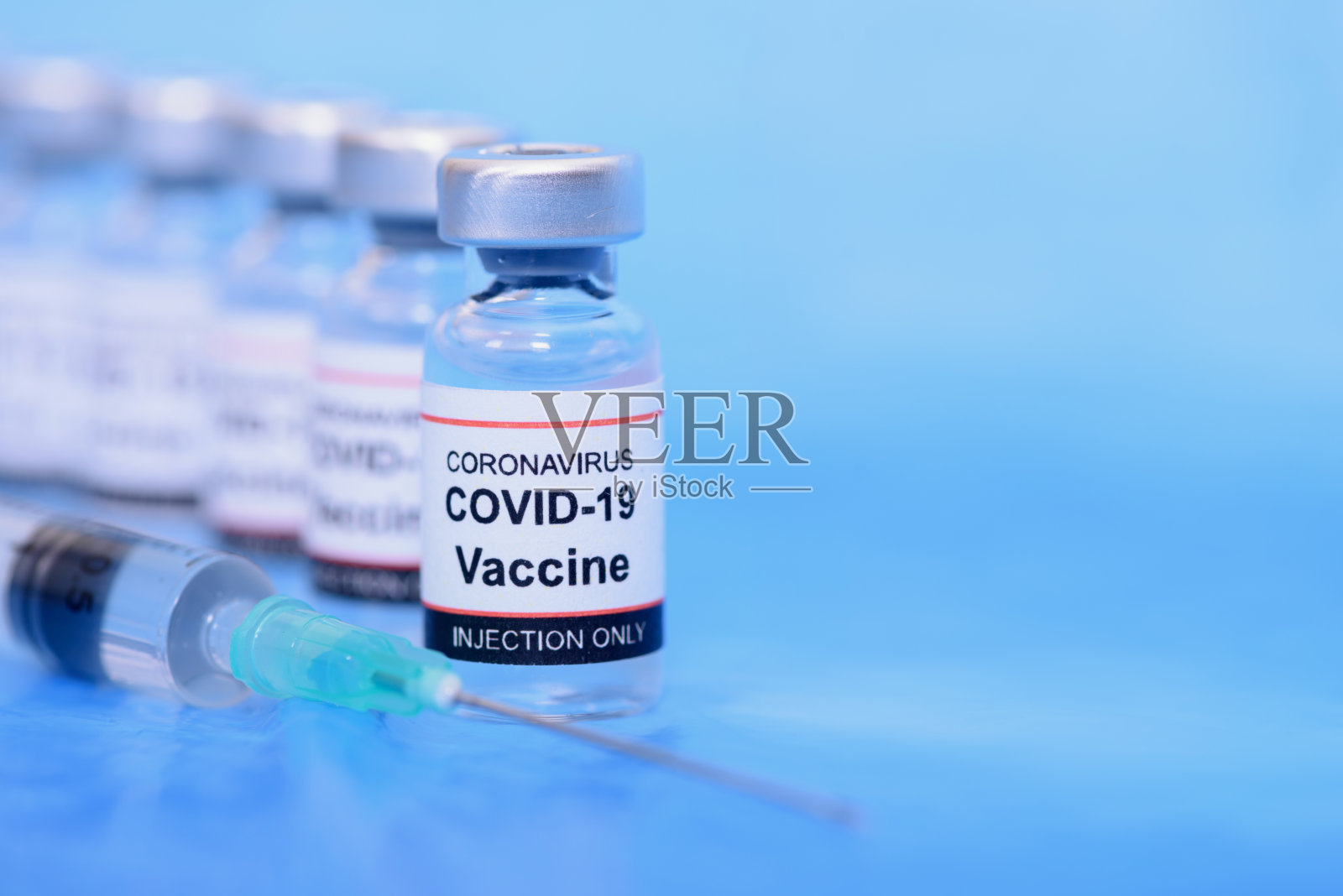 疫苗和医疗保健医学概念。预防、免疫和治疗冠状病毒感染的疫苗和蓝色背景注射器照片摄影图片