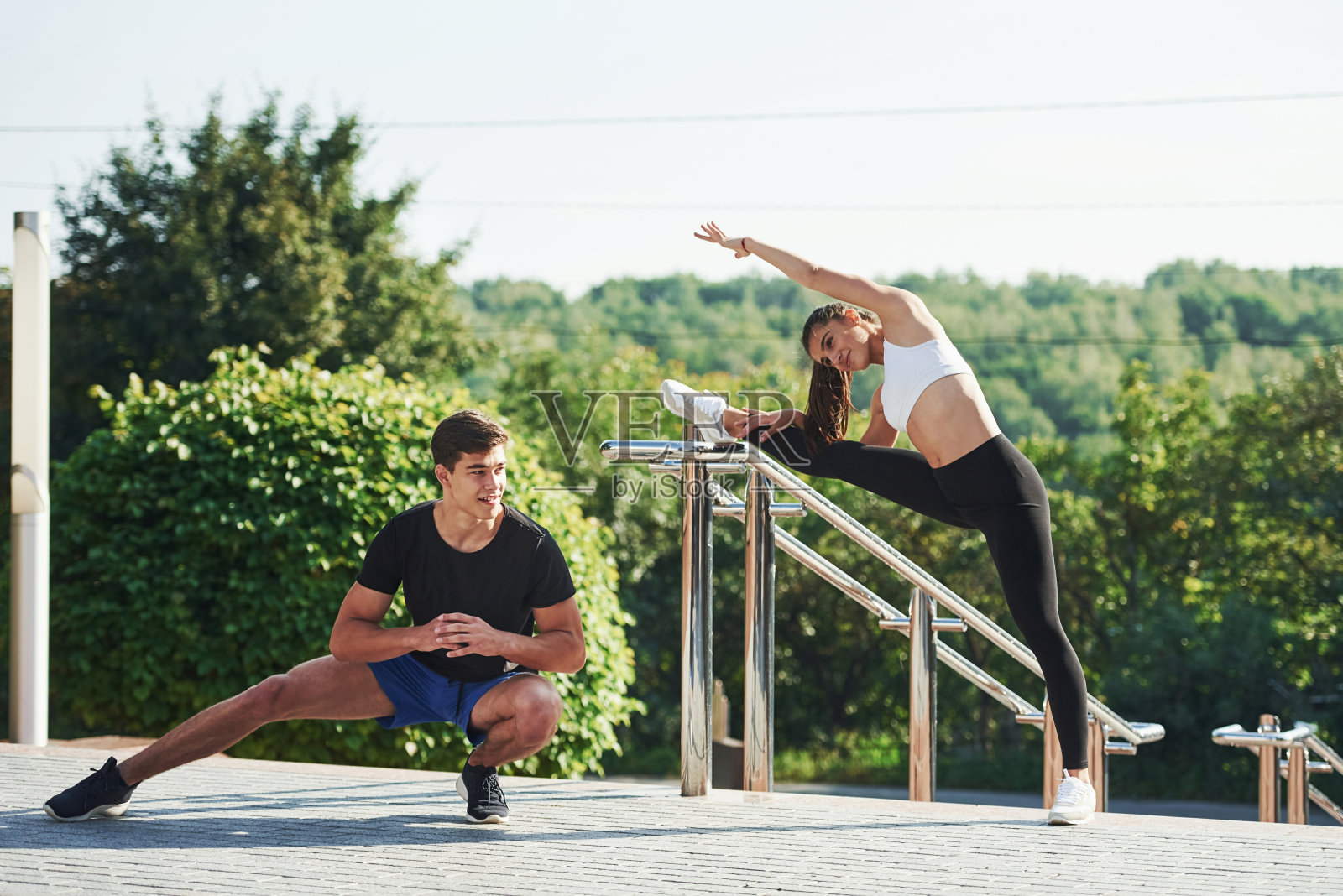 男人和女人在城市的白天有健身日。附近的栏杆照片摄影图片