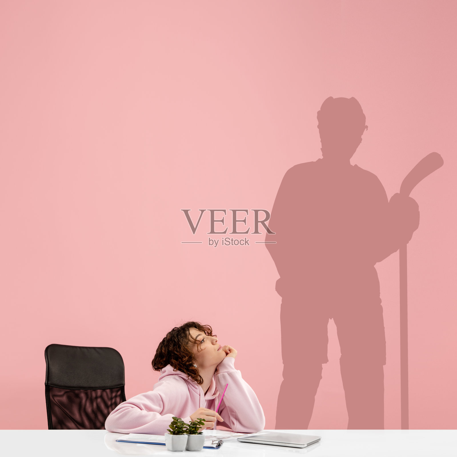 年轻女子梦想未来在大体育在她的工作在办公室。成为一个传奇。梦的影子在她身后的墙上。Copyspace。照片摄影图片