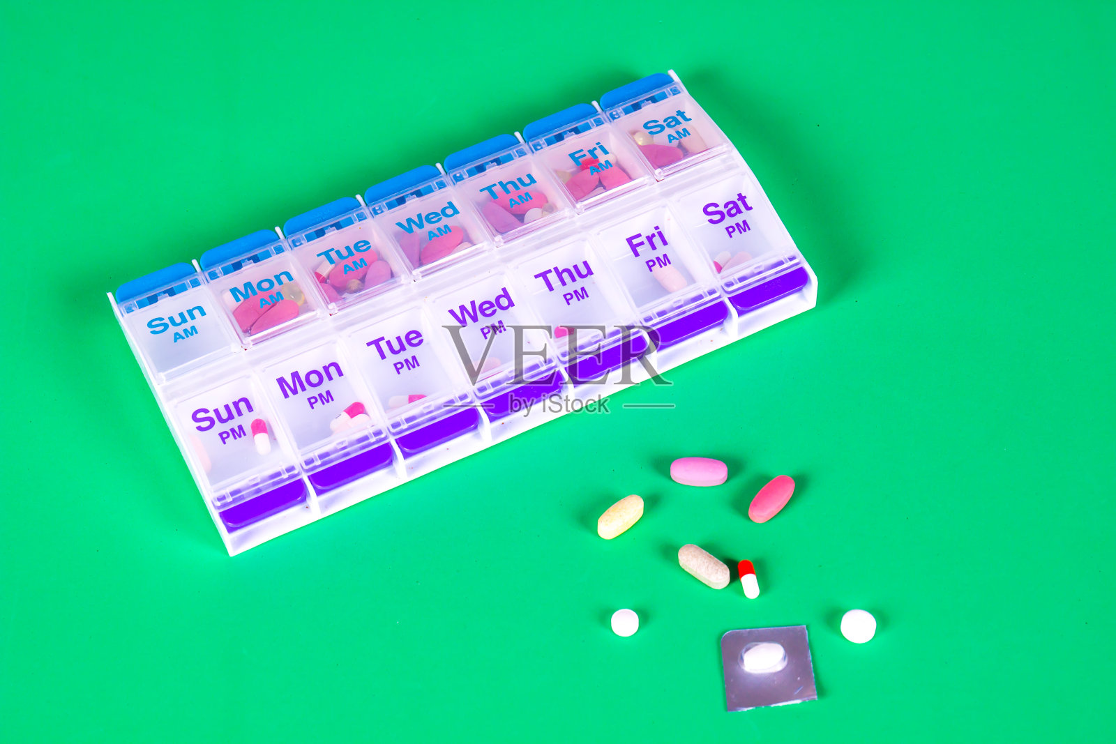 绿色背景上的每周药盒照片摄影图片