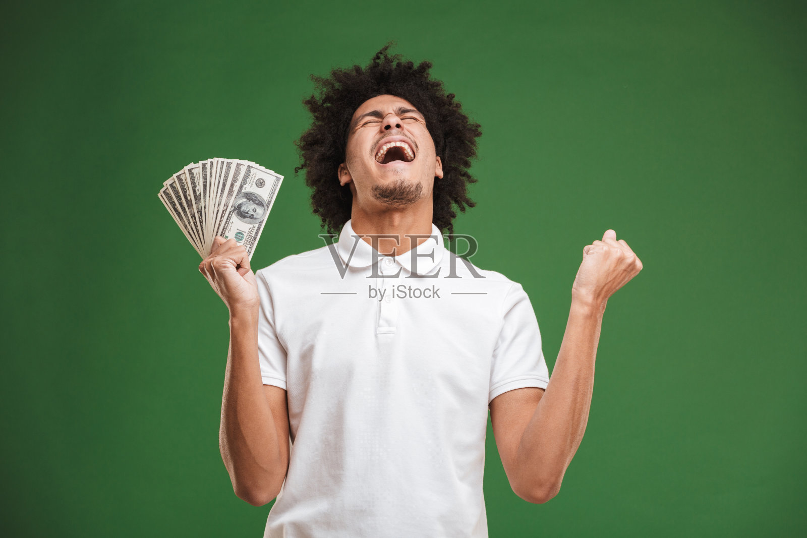 激动的情绪年轻的非洲卷曲的男人显示钱。照片摄影图片