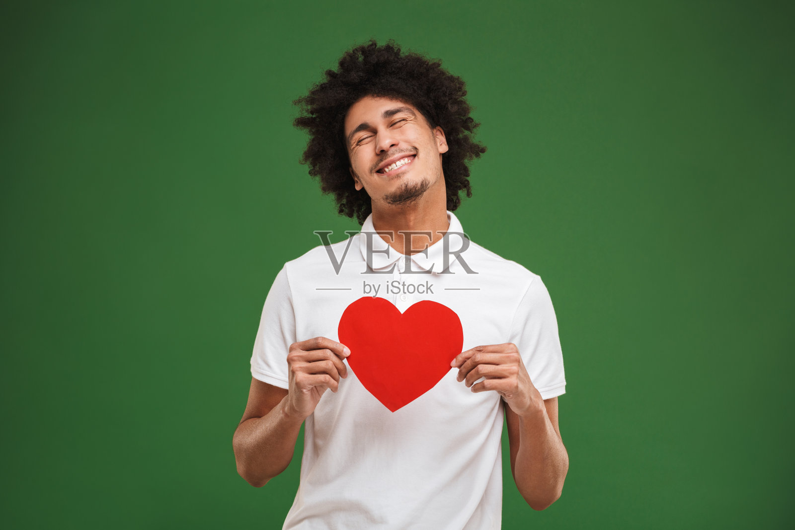 兴高采烈的年轻非洲卷发男人捧着心。照片摄影图片