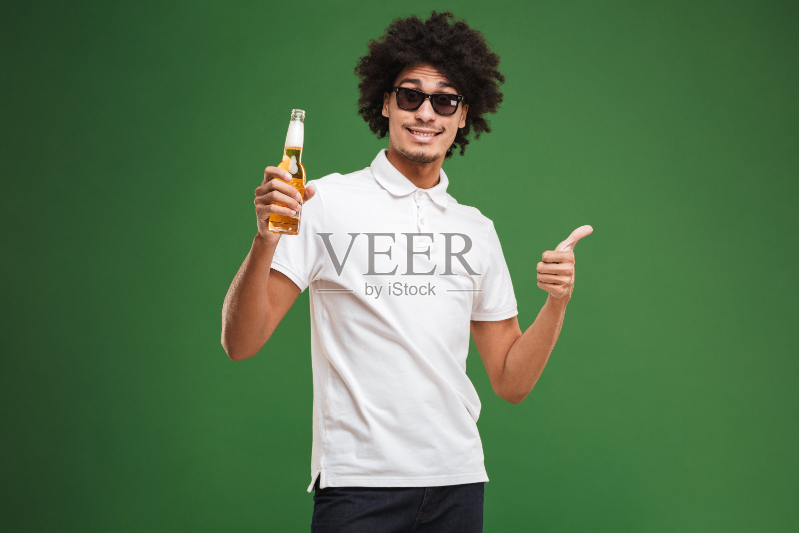 英俊的年轻非洲卷曲的男人喝啤酒竖起大拇指。照片摄影图片