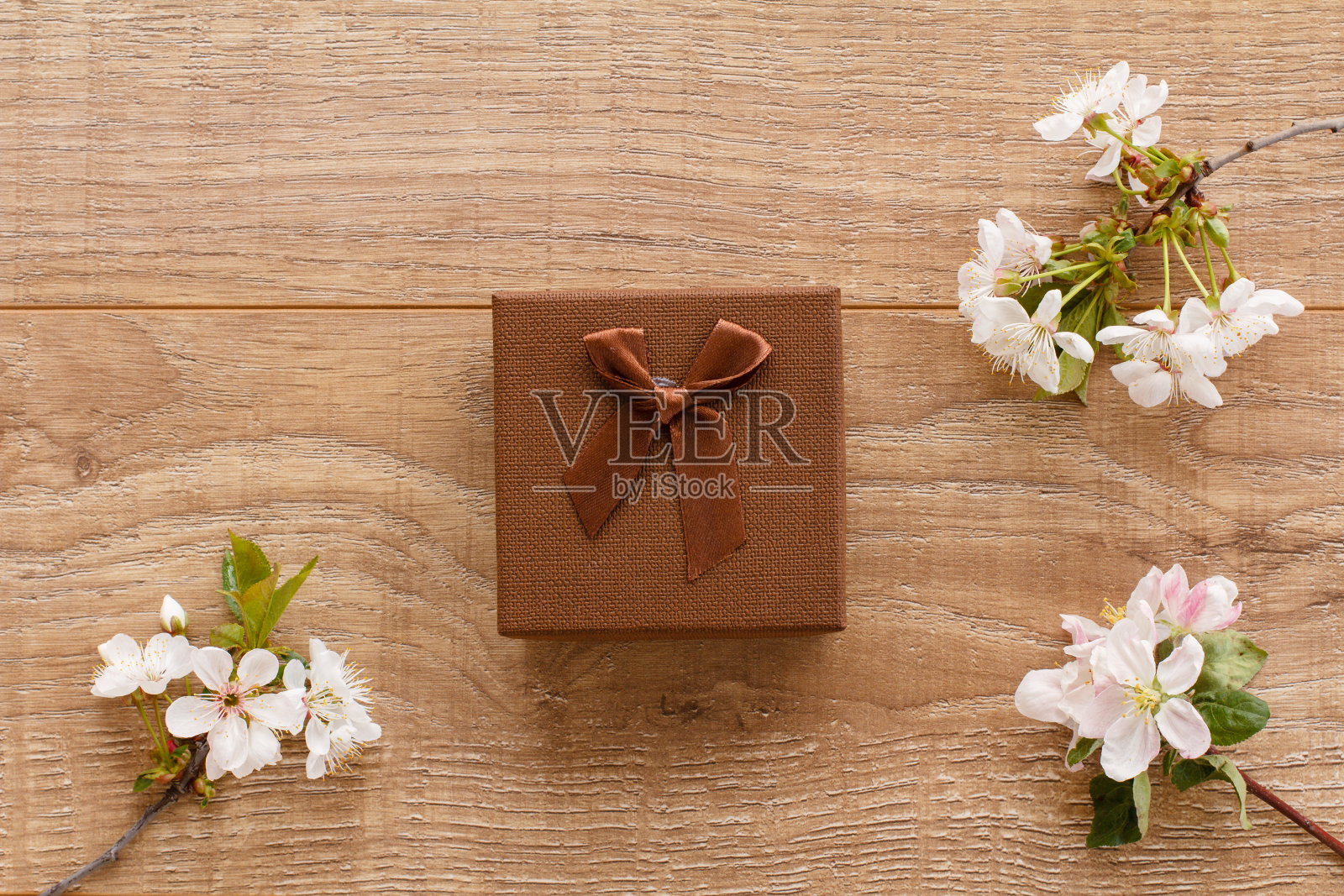 木制背景上有樱花的礼盒。照片摄影图片