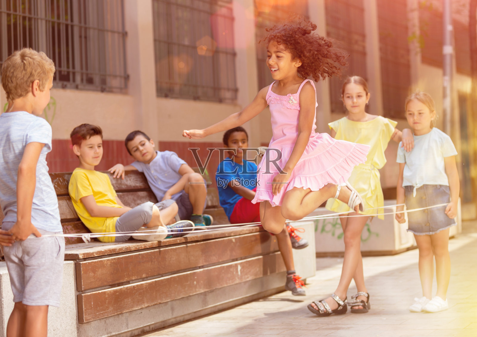 墨西哥女孩和欧洲朋友玩橡皮筋跳跃游戏照片摄影图片
