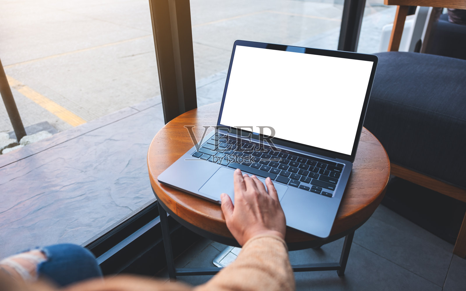 一位女士在咖啡馆使用并触摸笔记本电脑的触控板，白色的桌面屏幕照片摄影图片