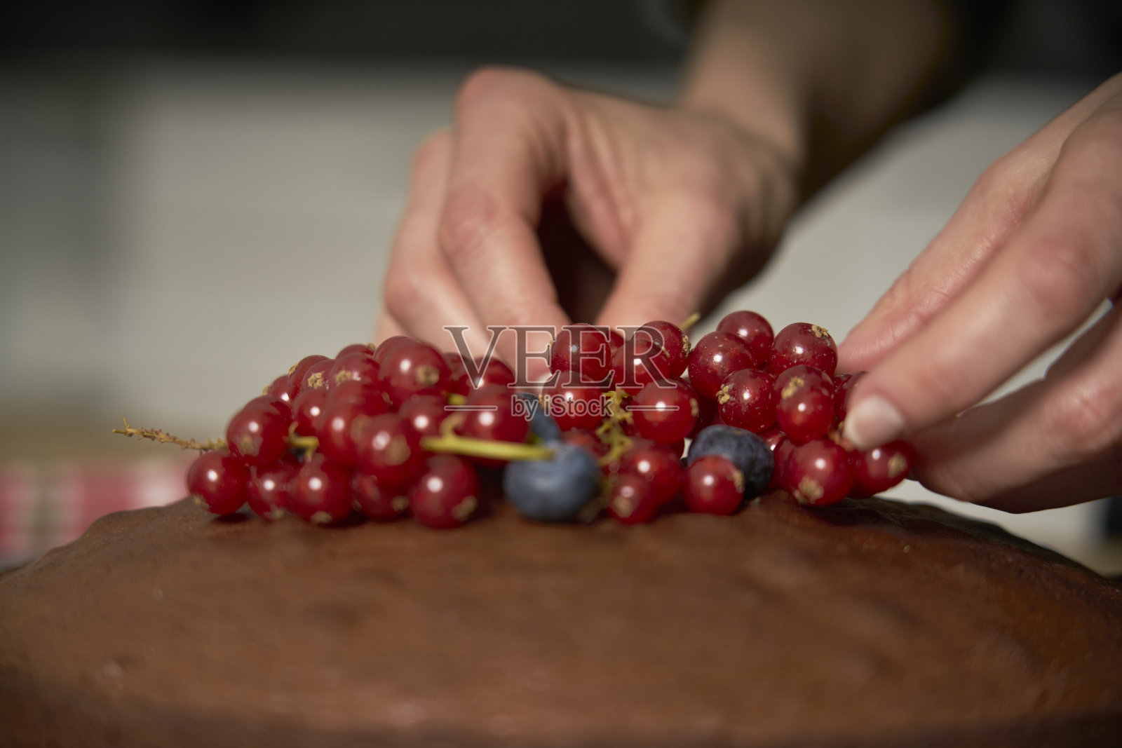 热爱烹饪的女士装饰手工巧克力蛋糕。照片摄影图片