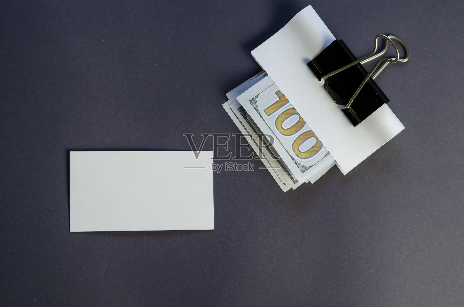 一百美元钞票，空白名片和夹在灰色背景。照片摄影图片